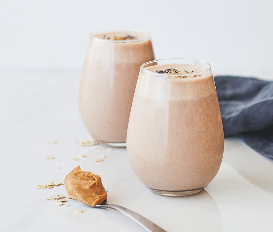 Two glasses of peanut butter protein smoothie with oats